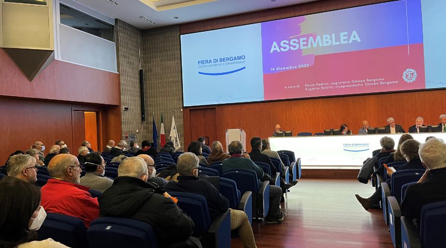immagine raffigurante uno scatto dell'assemblea dello scorso anno con scorcio della sala e dei partecipanti e tavolo dei relatori